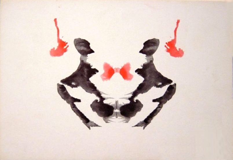 Rorschach card III, a black inkblot with red details